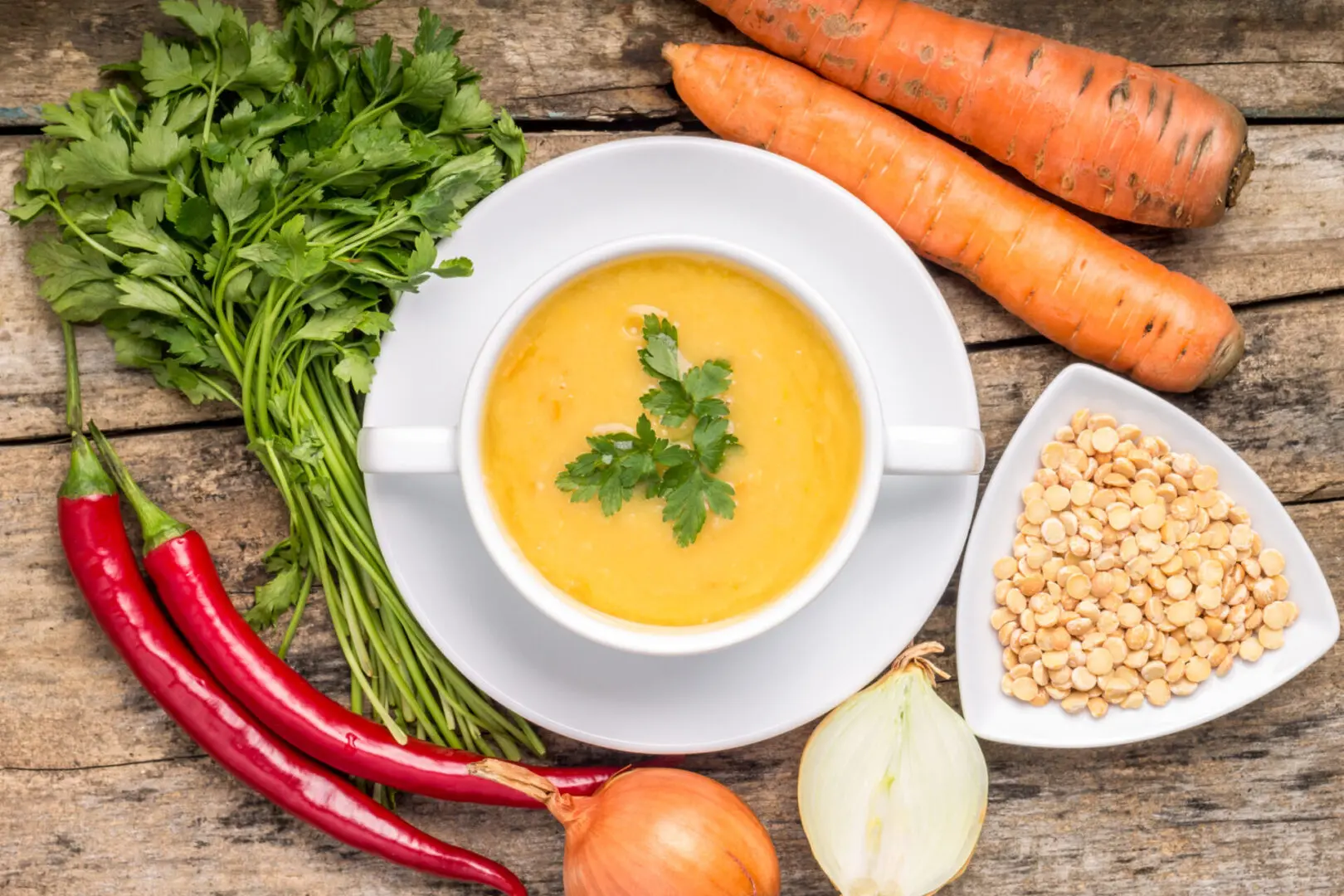 A bowl of soup with vegetables on the side.